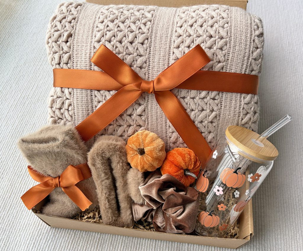 Nestlygift autumn self care gift set with beige knit blanket, fuzzy socks, glass tumbler and seasonal dried pumpkin decor